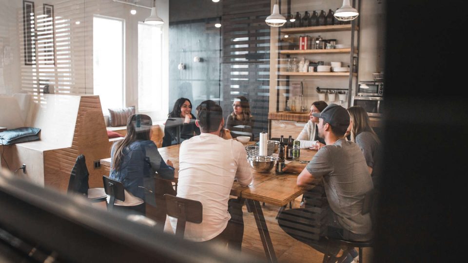 Junge Menschen sitzen zusammen am Tisch