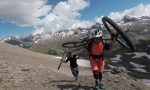 Frau und Mann tragen Mountainbike den Berg hoch