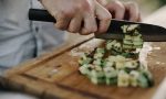 Koch schneidet Zucchini auf Holzbrett